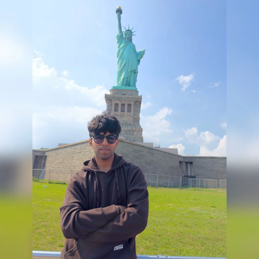 Prathyaksh Paramashiva in front of the Statue of Liberty after his US F-1 student visa was approved